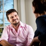 Stock image of two people tlaking in a counselling session