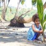 Fijian girl planting a palm