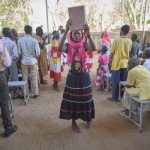 A woman carries the Bible into a Catholic Mass in Gidel