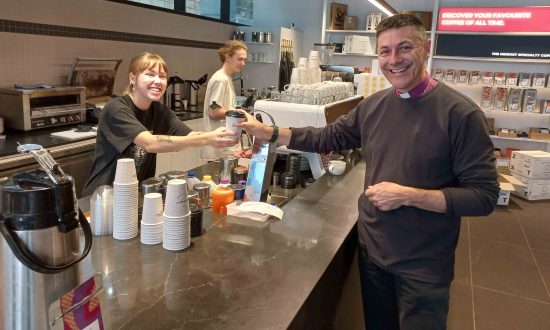 Eliza at The Hideout specialty coffee shop hands Bishop Jeremy his morning coffee