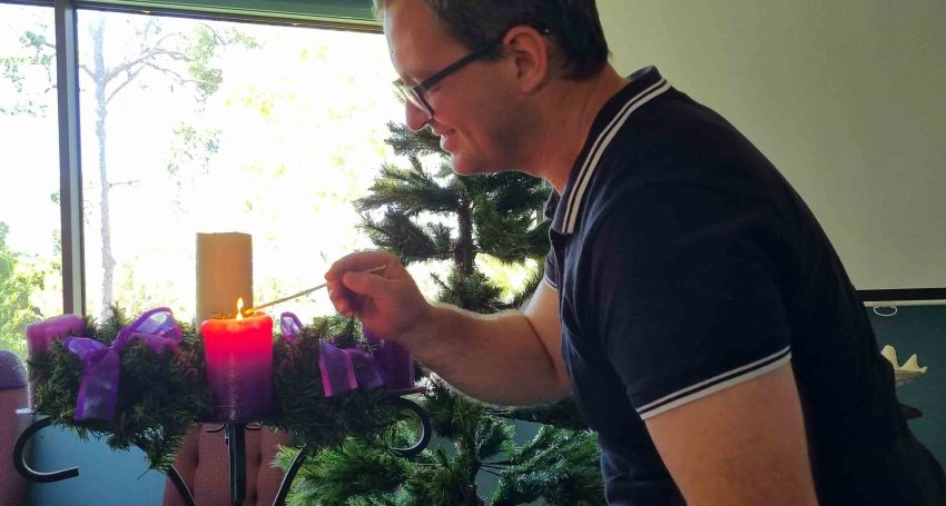 The Rev'd Andrew Schmidt test lighting the first Advent candle in the St Margaret’s, Nerang