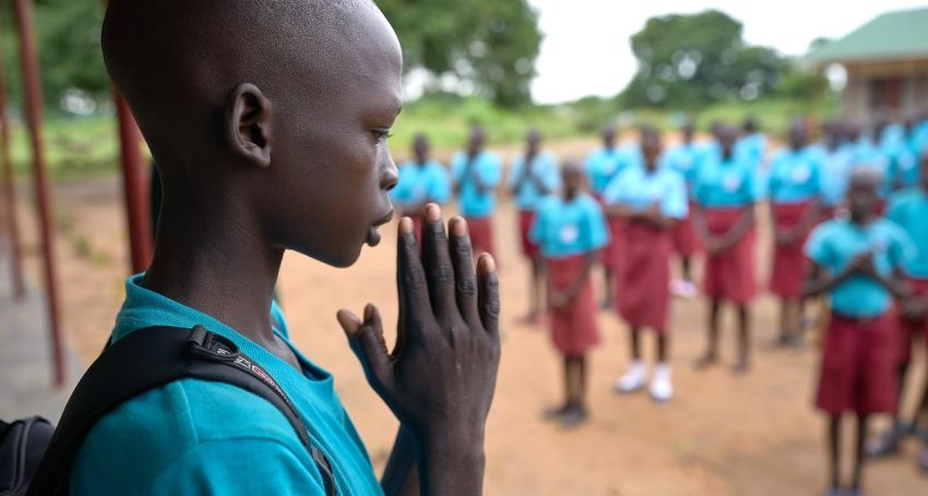 Children pray during the morning assembly at the Loreto Primary School