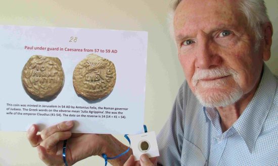 Dr Peter Lewis with a bronze coin