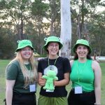 Sarah Warburton, Sophia Colledge and Amy Stalley, co-dorm leaders for the green frogettes dorm holding their mascot, at Senior Ichthus in 2023