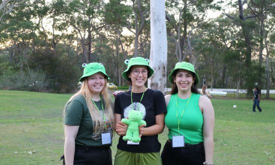Sarah Warburton, Sophia Colledge and Amy Stalley, co-dorm leaders for the green frogettes dorm holding their mascot, at Senior Ichthus in 2023