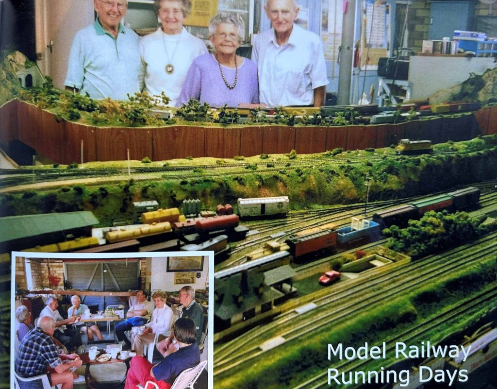 Group of people standing around a model railway 