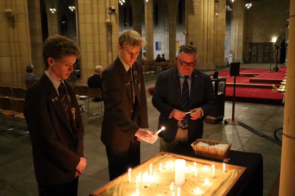 Students and teacher lighting candles at the Cathedral prayer vigil 