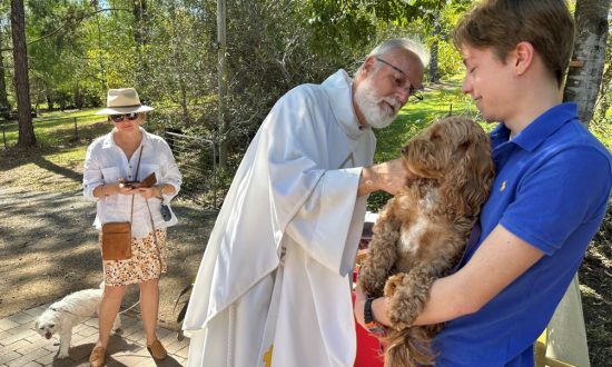 The Rev'd Robert Paget blessing a dog during the Season of Creation