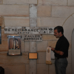 Chaplain The Ven. Rob Sutherland CSC beside a WW II memorial cross at St John’s Church, Gordon in 2015