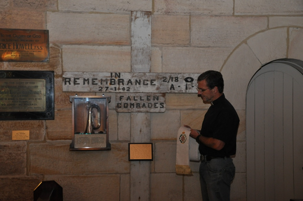 Chaplain The Ven. Rob Sutherland CSC beside a WW II memorial cross at St John’s Church, Gordon in 2015