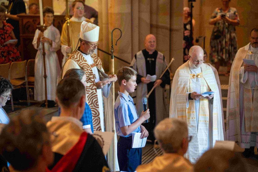 Two school students welcoming Archbishop-elect Jeremy Greaves to the Cathedral