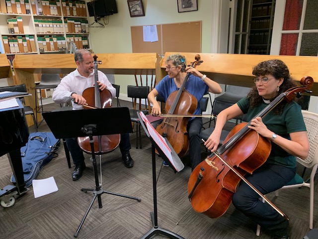 Three people playing cello