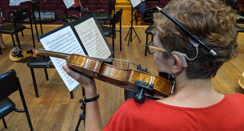 Woman with cochlear implant playing violin