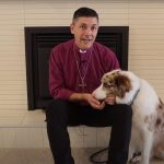 Archbishop Jeremy Greaves sitting with border collie Paddy at home