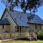 Old yellow timber church with tin roof in the bush