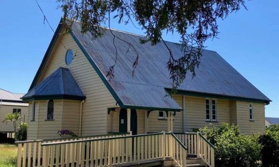 Old yellow timber church with tin roof in the bush