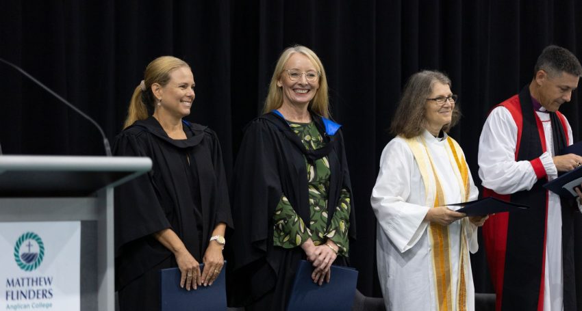 Staff and clergy at a commissioning service in a school auditorium