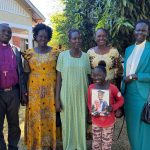 A South Sudanese bishop, three South Sudanese women, a South Sudanese child holding a photograph and a South Sudanese priest