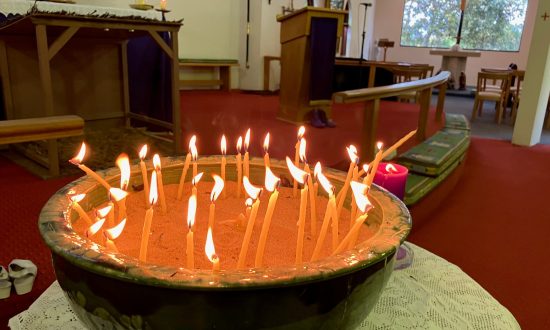 Image of lit candles in a large bowl filled with sand