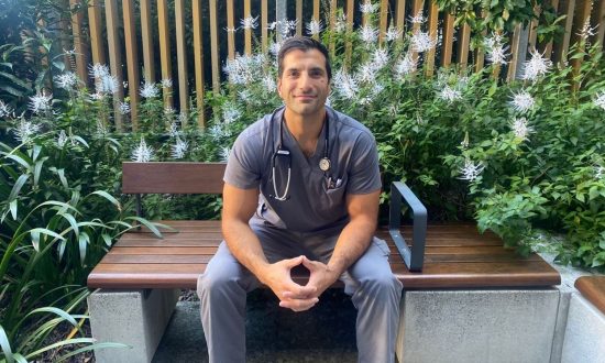 Doctor in scrubs sitting on a park bench