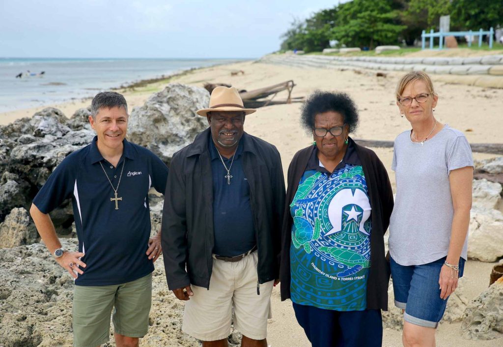Four people standing on a beach in the Torres Strait Islands 
