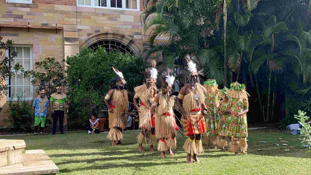 Torres Strait islander dancers outside a Cathedral dancing 