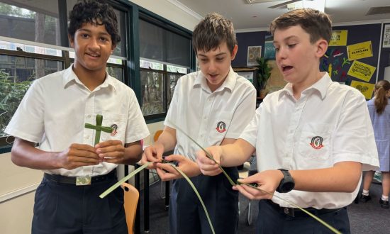 Teenage boy school students in uniform making palm crosses