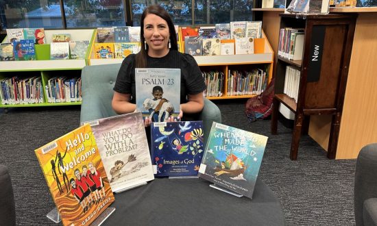 Woman sitting in a library surrounded by kids' books