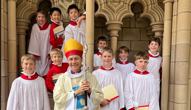Boy choristers outside a Cathedral with an Archbishop