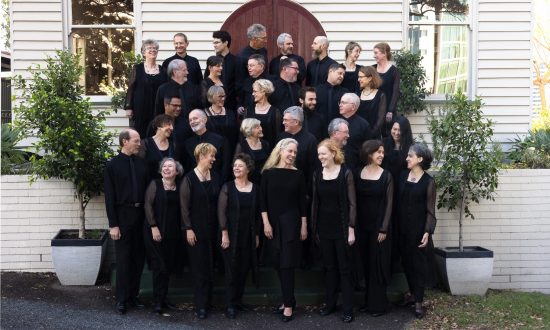 Large choir wearing black standing outside