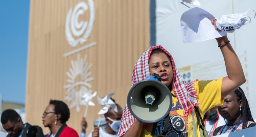 Woman at a protest with a megaphone at a United Nations climate change conference