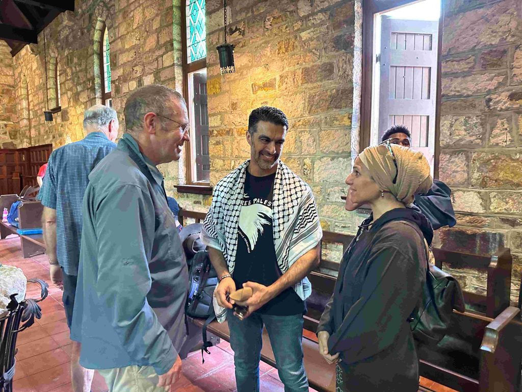 An Anglican bishop, a Muslim man wearing a keffiyeh and a Muslim woman in a chapel