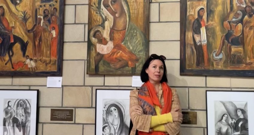 Award-winning Brisbane artist Olga Bakhtina standing in front of several art works at St John’s Anglican Cathedral