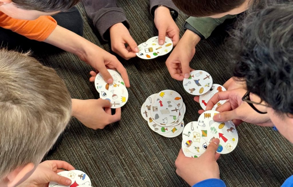 Children playing SEEK card game together on the floor