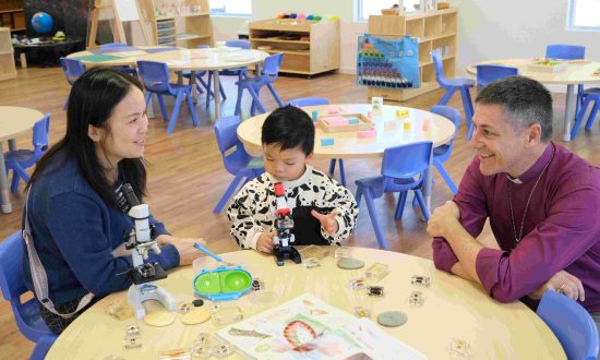 A woman and a young child with a bishop sitting around a child in an early learning centre