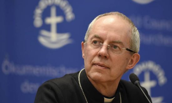 Priest in black shirt and collar with microphone