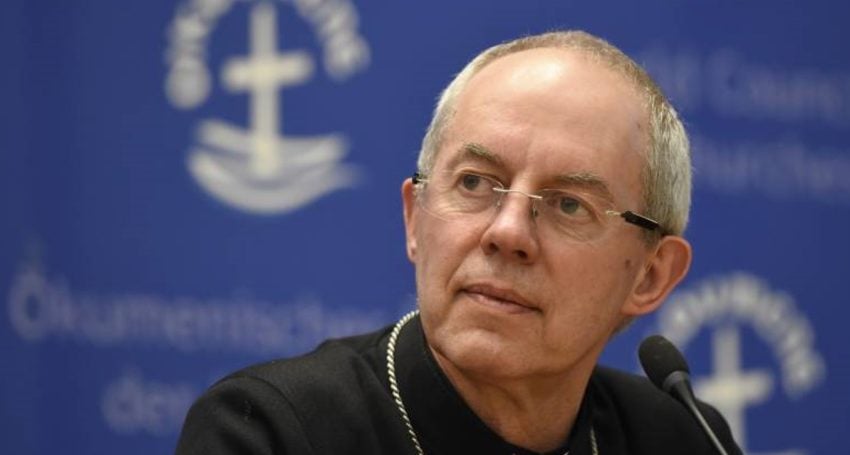 Priest in black shirt and collar with microphone