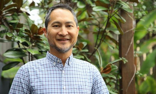 Middle-aged man in plaid blue and white shirt smiling, looking at the camera