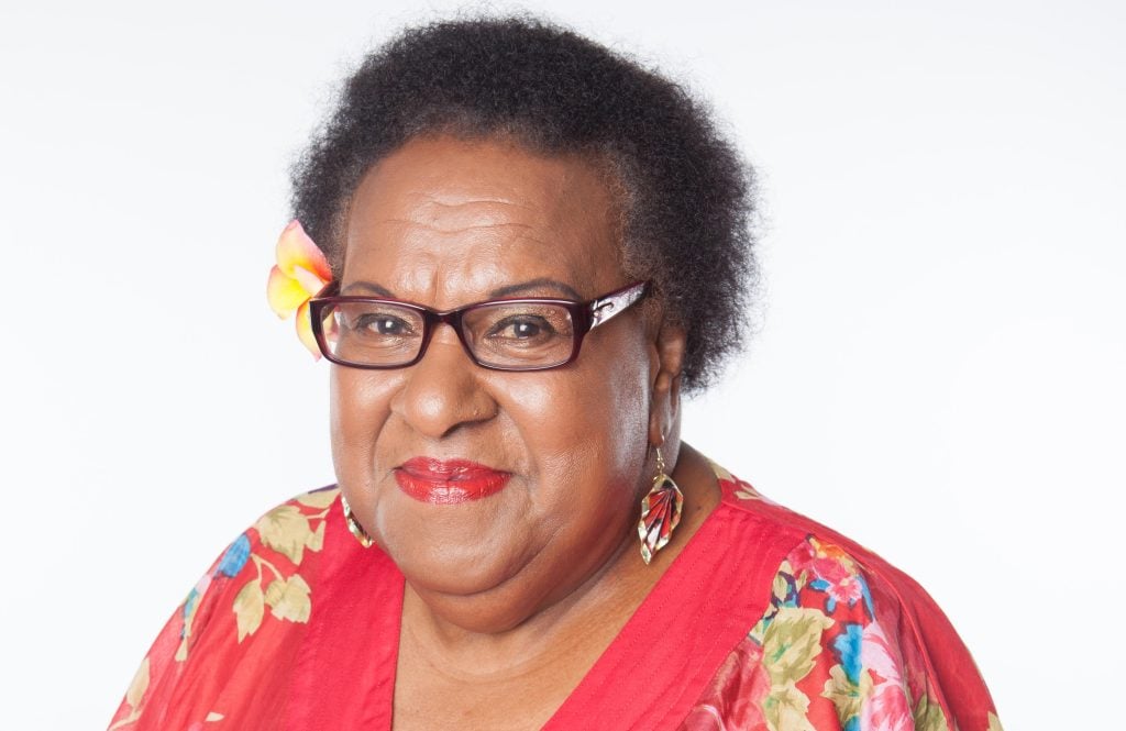 Torres Strait Islander elder wearing a red blouse smiling 