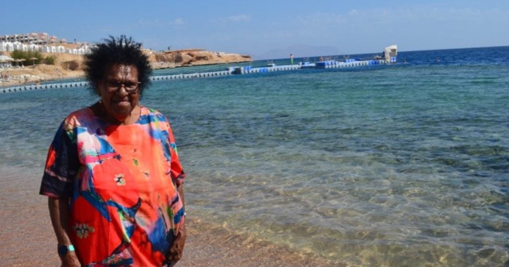 Torres Strait Islander elder walking by the red sea