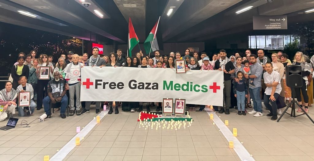 People gathered behind a "Free Gaza Medics" sign after a vigil 