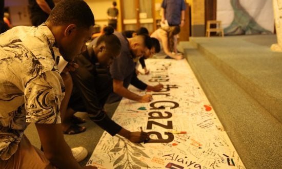 Inter-faith young people signing a prayer banner for Gaza