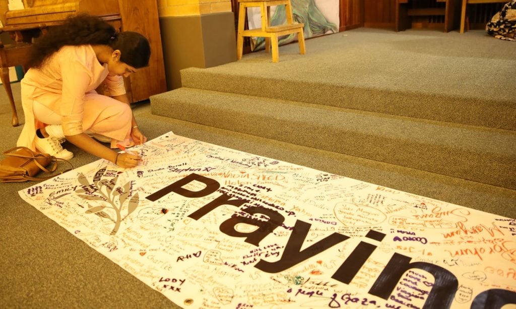 Young Tamil Hindu woman signing a prayer banner