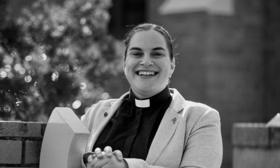 Woman priest smiling and sitting