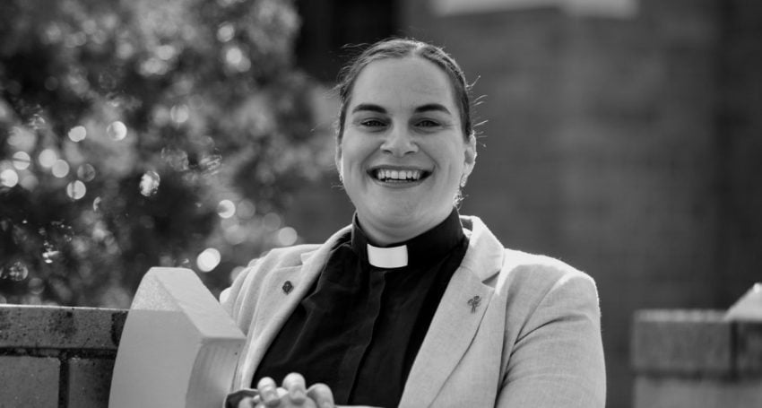 Woman priest smiling and sitting