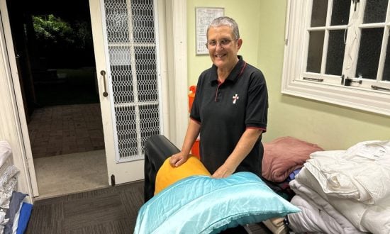 Woman deacon putting out mats, blankets and pillows for rough sleepers at a Cathedral