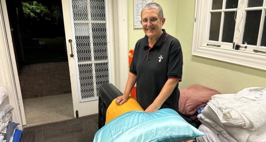 Woman deacon putting out mats, blankets and pillows for rough sleepers at a Cathedral