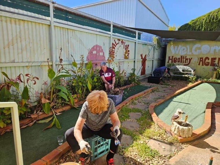 Two people working in the garden of an outback rectory 