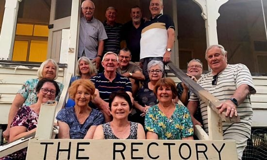 Group of people in front of an outback rectory