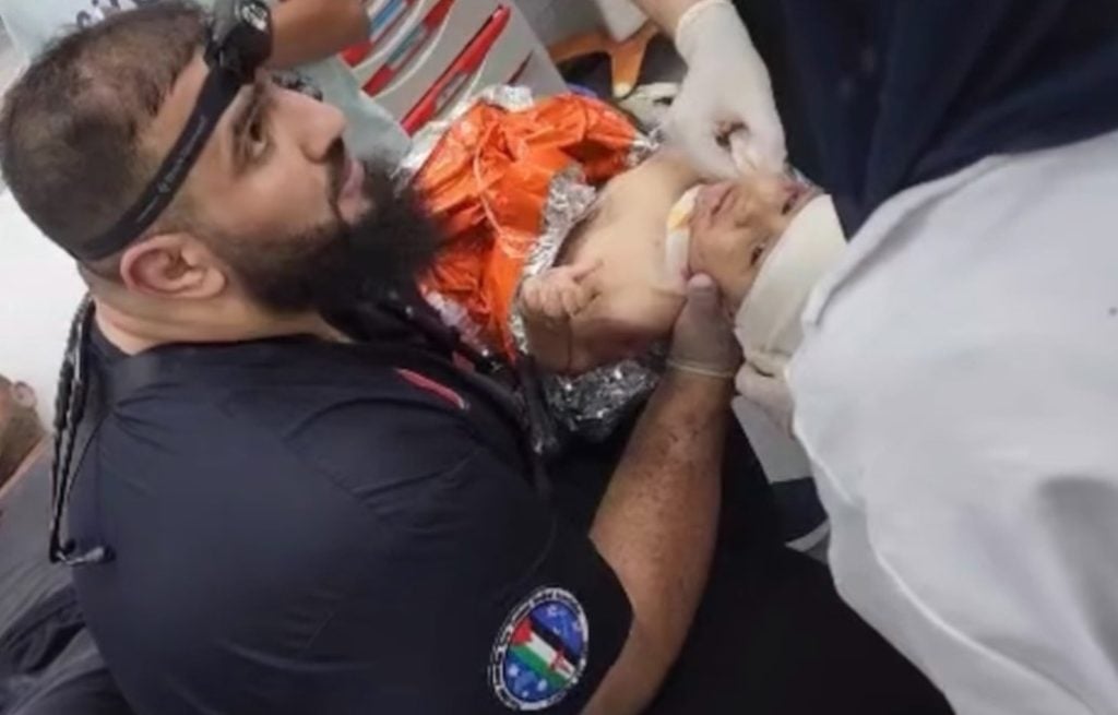 Male emergency medicine physician caring for a child in a Gaza hospital 